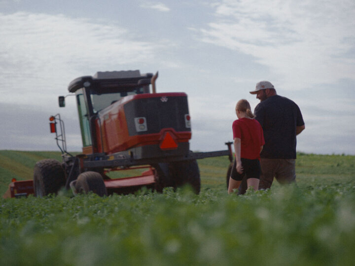 People walking in field by combine